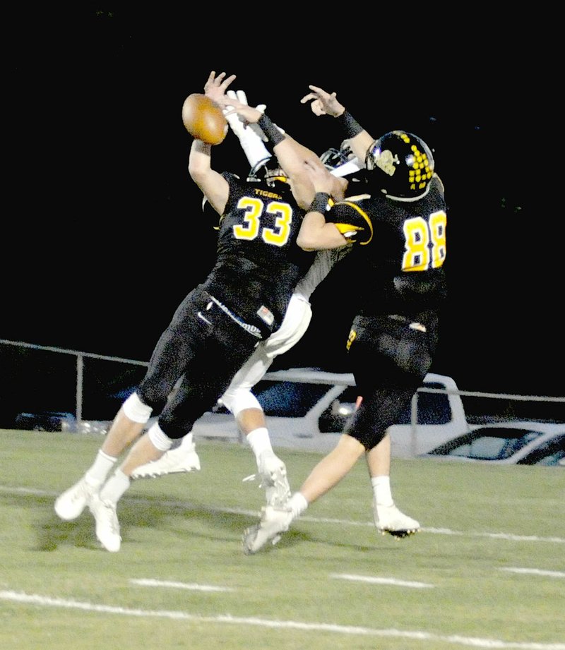 MARK HUMPHREY ENTERPRISE-LEADER Twin brothers Stone Bryant (No. 33) and Collin Bryant (No. 88) combine to break up a pass inside the Tiger five. Both brothers had interceptions and the Tigers forced Shiloh Christian to turn the ball over on downs five times in the first half. Prairie Grove won 35-21 Friday.