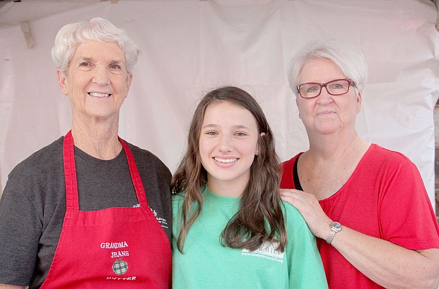 Jean Helm, left, of Lincoln, has been making apple butter for the Arkansas Apple Festival for 20 years. Her helpers this year included her youngest grandddaughter, Mollie Jean Helm of Stilwell, Okla., and her sister, Linda Godden of Lincoln. Helm had 500 jars of apple butter to sell at the 42nd festival.