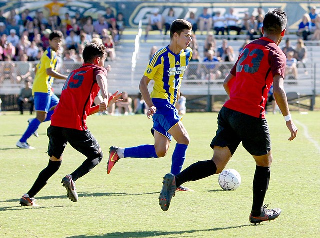 Photo courtesy of JBU Sports Information John Brown freshman Elias McCloud dribbles the ball through the Mid-America Christian (Okla.) defense during Saturday's homecoming match. John Brown won the match 2-1 on a goal with 13.9 seconds left by Kelvin Omondi.