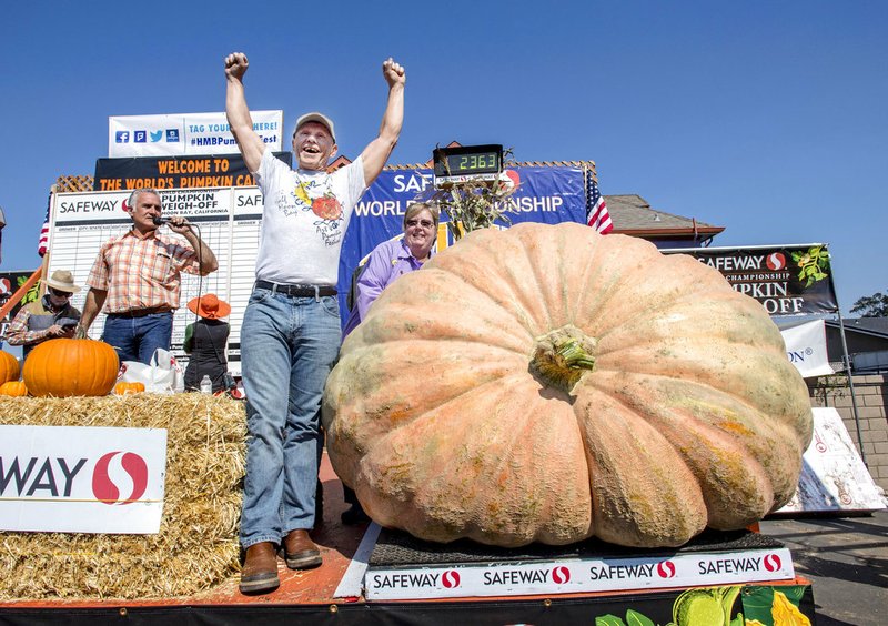 Joel Holland throws his arms into the air after winning the 44th World Championship Pumpkin Weigh-Off in Half Moon Bay, Calif., on Monday, Oct. 9, 2017. 