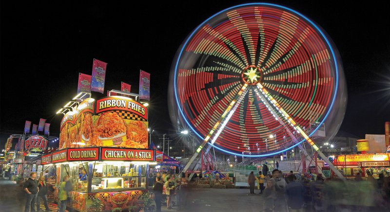 Visitors to the Arkansas State Fair walk the midway Thursday night as rides and food booths light up the night sky.