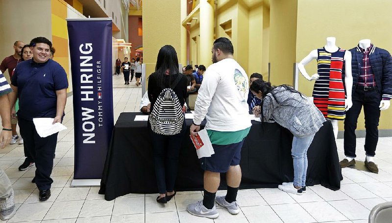 Job seekers gather at a job fair booth on Oct. 3 in the Dolphin Mall in Sweetwater, Fla. August job openings fell slightly to just under 6.1 million, the Labor Department said Wednesday, from 6.14 million in the previous month. 