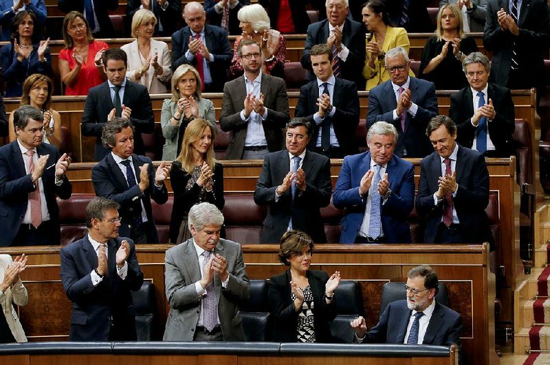 Prime Minister Mariano Rajoy (bottom right) is applauded by party members after his speech Wednesday at the Spanish parliament in Madrid. Rajoy said he rejected offers of mediation in the Catalonia crisis, and called for respect of Spanish law, a day after Catalan officials signed what they called a declaration of independence from Spain. 