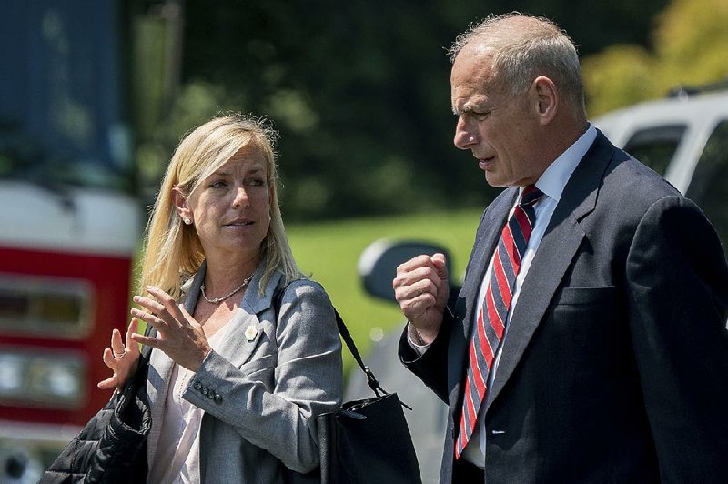 In this Aug. 22, 2017 photo, White House Chief of Staff John Kelly and Deputy Chief of Staff Kirstjen Nielsen speak together as they walk across the South Lawn of the White House in Washington. 