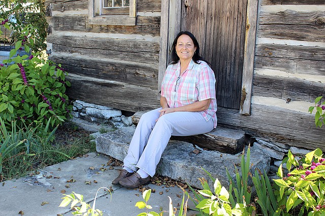 MEGAN DAVIS MCDONALD COUNTY PRESS/Dana Banta, McDonald County Victim's Advocate, sits on the steps of the first McDonald County Courthouse.