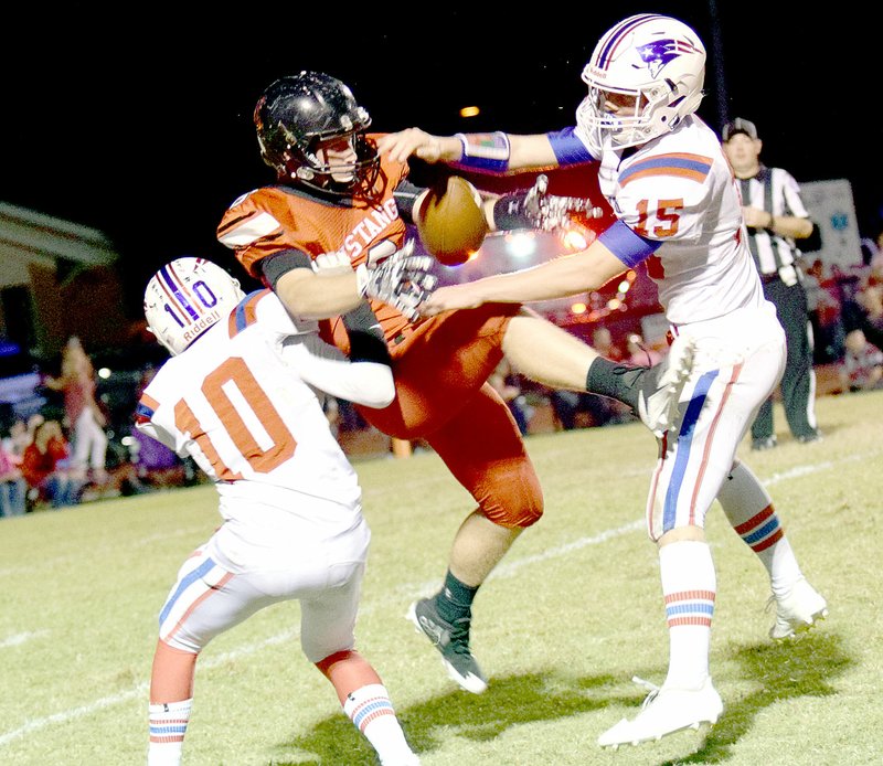 Photo by Rick Peck McDonald County's Oakley Roessler makes a circus catch between East Newton defensive backs Austin Brewster (10) and Brett Pendergraft (15) during the Mustangs' 54-0 win on Oct. 6 at MCHS.