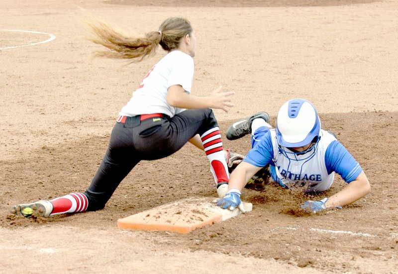 Carthage's Sydney Peters dives back to first base to just beats a tag by McDonald County's Leslie Yousey during the Lady Tigers 3-1 win in the Missouri Class 4 District Softball Tournament on Oct. 5 at Carthage High School.