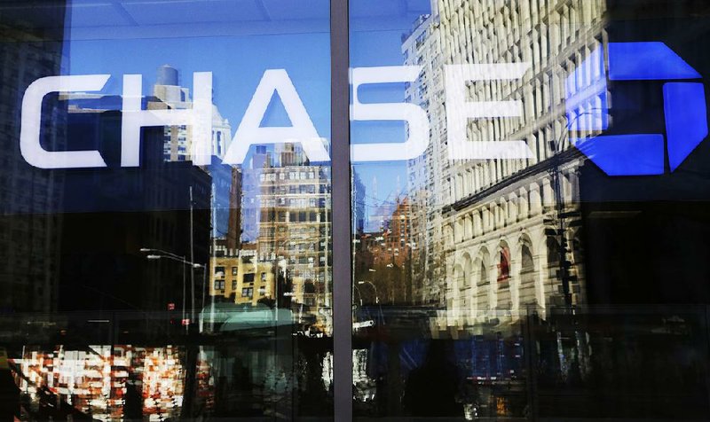 New York towers are re!ected in a window on a Chase bank branch in this file photo. JPMorgan Chase & Co. on Thursday reported a third-quarter profit of $6.73 billion.