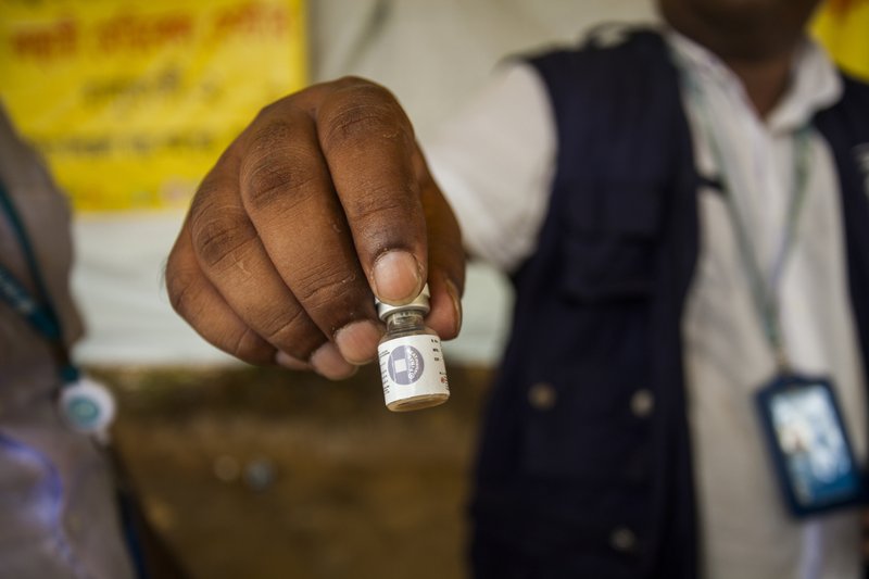 A man displays a vaccine bottle that health workers are administering to Rohingya refugees at the Balukhali makeshift camp in Cox's Bazar, Bangladesh, Thursday, Oct. 12, 2017. 