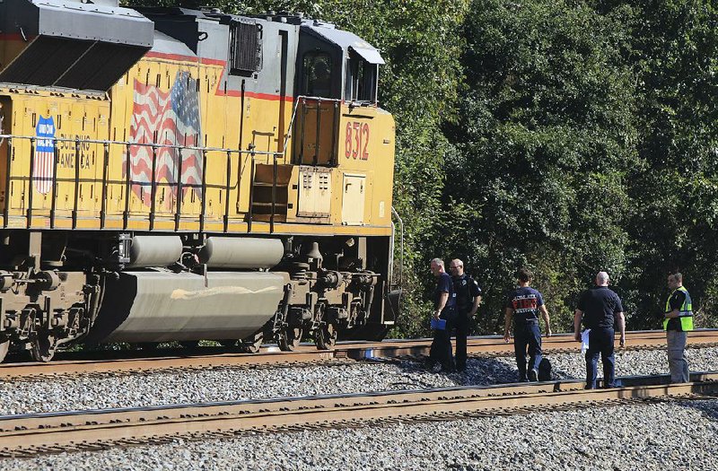 Emergency personnel investigate an accident Friday morning in which a pedestrian was hit and injured by a train in Little Rock near Geyer Springs Road and West 65th Street. 