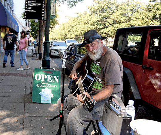 The Sentinel-Record/Mara Kuhn ENTERTAINER: Charlie Jacobson, of Hot Springs, sings to pedestrians in downtown Hot Springs on Friday.