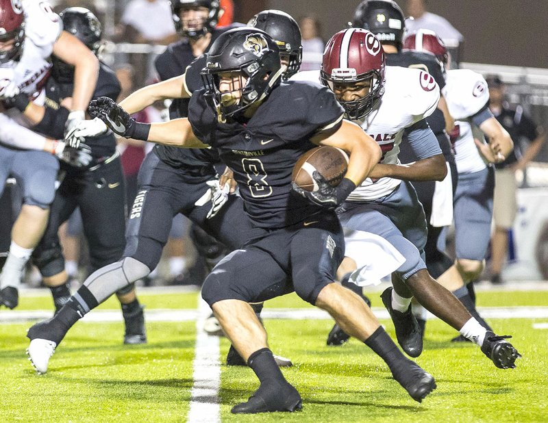 Bentonville High's Easton Miller (8) looks for running room Friday against Springdale High at Tiger Stadium in Bentonville.