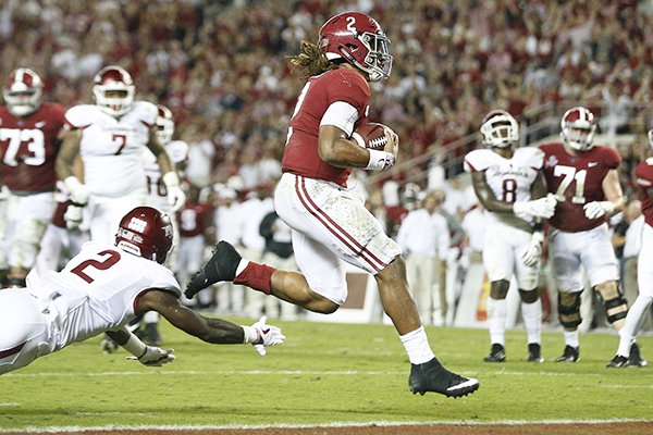 Alabama quarterback Jalen Hurts runs in for a touchdown against Arkansas defensive back Kamren Curl during the first half an NCAA college football game against, Saturday, Oct. 14, 2017, in Tuscaloosa, Ala. (AP Photo/Brynn Anderson)

