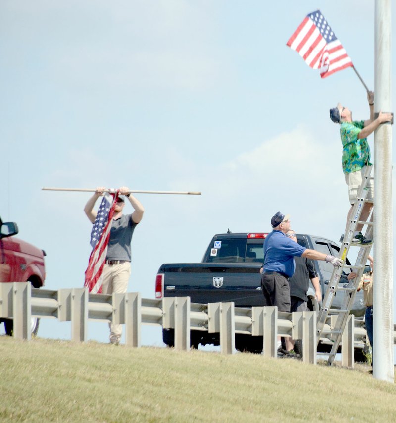 Michael Burchfiel/Herald-Leader Members of the Siloam Springs American Legion changed some of the flags along U.S. Highway 412.