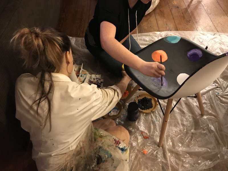 Eve Smith, artist and curator at the Arts Center of the Ozarks, paints with a client at the Bell House, part of the Children's Campus at Youth Bridge. These works of art will be auctioned off at the Nox Stellata fundraiser.