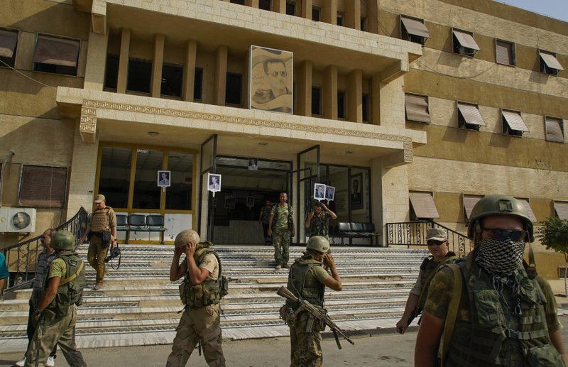 In this Sept. 15, 2017 file photo, Russian military police soldiers walk outside a hospital in Deir el-Zor, Syria. Syria state media says pro-government troops have seized the Islamic state stronghold town of Mayadeen after weeks of fighting for control of the oil-rich eastern Deir el-Zour province that straddles the border with Iraq. 