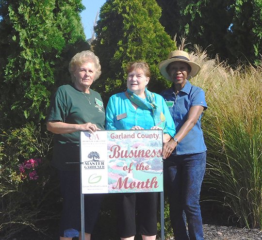 Submitted photo LANDSCAPE RECOGNIZED: Garland County Master Gardeners Carolyn Davis, left, Gaye Harper, Evelyn Worsham and, not shown, Jennetta Sanders placed the Business of the Month sign at the entrance to Hobby Lobby and Kroger on Central Avenue.