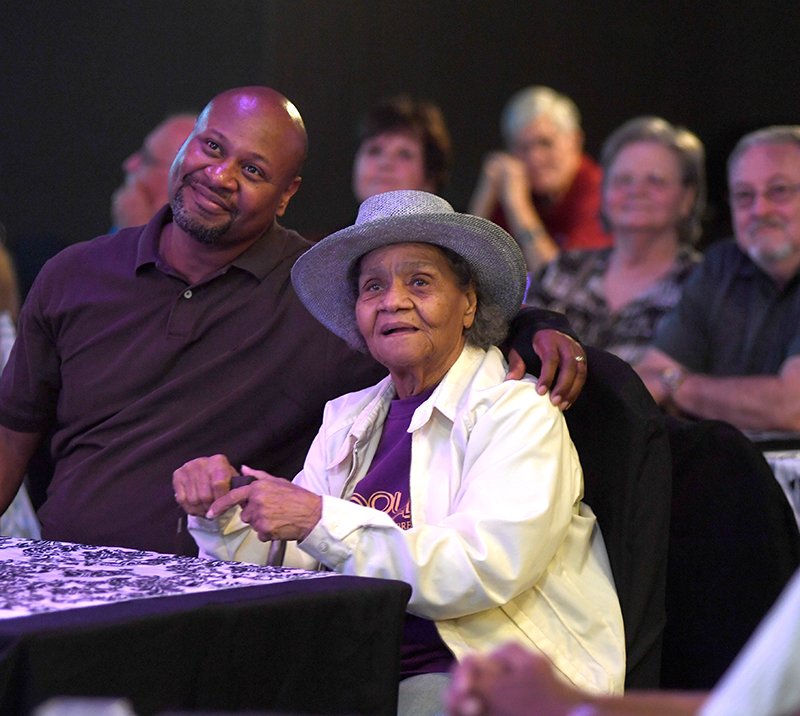 The Sentinel-Record/Mara Kuhn HONORED RELATIVES: Arthur Simril, of Washington, D.C., left, and his mother, Fannie Simril, of St. Louis, watch a video about Fannie Simril's brother, professional baseball player Art Pennington, during Pennington's induction into the Arkansas Walk of Fame Saturday.