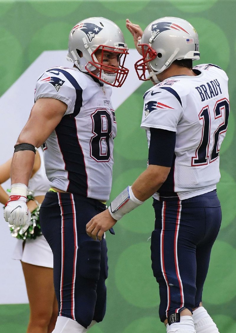 New England Patriots teammates Tom Brady (12) and Rob Gronkowski (87) celebrate after the two connected for a touchdown during the second half Sunday.