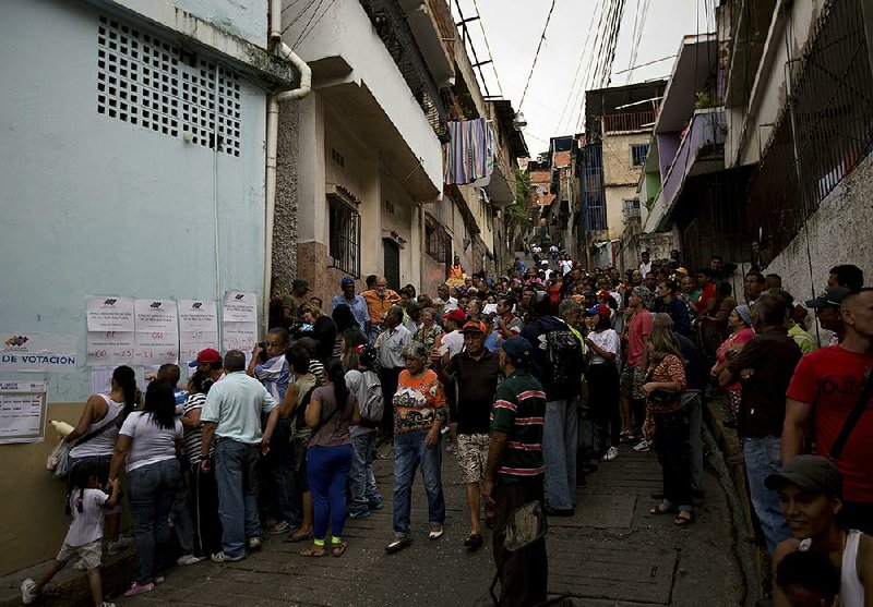 Voters wait in line outside a polling station Sunday to cast their ballots during regional elections in Caracas, Venezuela.