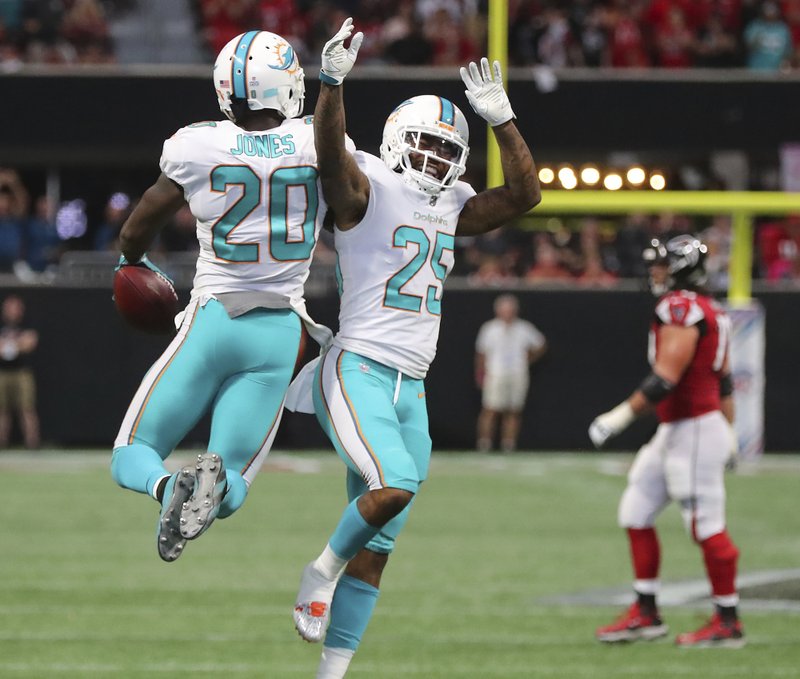 Miami Dolphins safety Reshad Jones, left, celebrates with Xavien Howard after intercepting a pass from Atlanta Falcons' Matt Ryan during the final minute of an NFL football game Sunday, Oct. 15, 2017, in Atlanta.