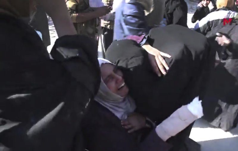 This frame grab from a video provided on Friday, Oct. 13, 2017 by Turkey-based Kurdish Mezopotamya agency media outlet that is consistent with independent AP reporting, shows an injured Syrian woman, center, reacts as she hugs another woman after they fled from the areas that still controlled by the Islamic State militants, in Raqqa, Syria. Scores of civilians including women and children are fleeing the last few remaining neighborhoods held by the Islamic State group in Syria's northern city of Raqqa, ahead of an anticipated final push by U.S.-backed fighters seeking to liberate the city. 