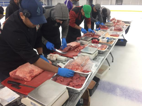 A group of men compete in Texas Roadhouse's annual meat-cutting competition. 