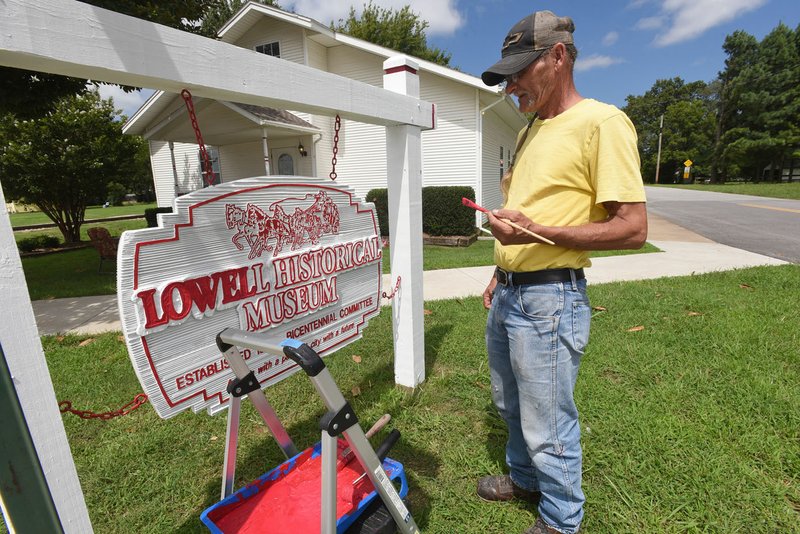 Roy Baker of Rogers paints the entrance sign Wednesday Aug. 24 2017 at the Lowell Historical Museum, 304 Jackson Place, in downtown Lowell. The new red and white color should be more visible to passers by, Baker said. The museum displays hundreds of items from Lowell's history, plus old-time kitchen ware, musical instruments, documents and military items. The museum is hosting a back to school bash with games, food and prizes at 6 p.m. today at Ward Nail Park. Lowell Historical Museum is open Monday through Thursday from 9 a.m. to 2 p.m., and Saturday from 10 a.m. to 4 p.m. It is closed Fridays.
