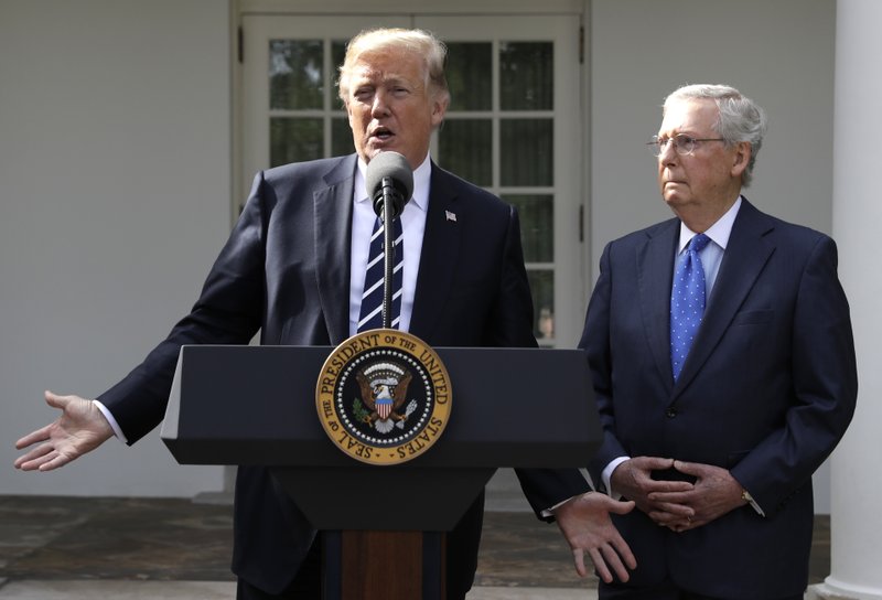 President Donald Trump answers questions with Senate Majority Leader Mitch McConnell, R-Ky., in the Rose Garden at the White House, Monday, Oct. 16, 2017, in Washington. 