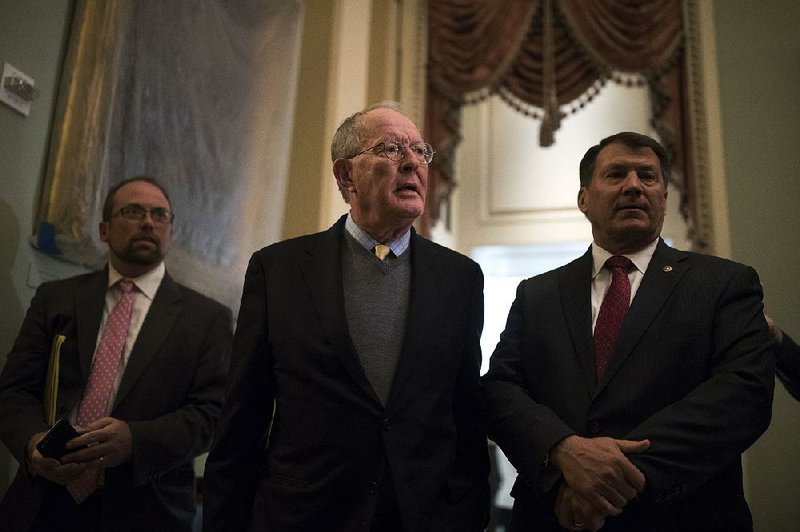Republican Sen. Lamar Alexander (left), accompanied by Sen. Mike Rounds of the same party, speaks Tuesday on Capitol Hill in Washington about a two-year deal with Sen. Patty Murray, a Democrat, that would provide funding for key subsidies to health insurers.  