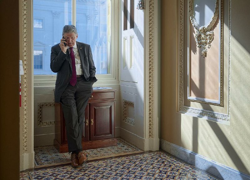 Sen. Joe Manchin does a phone interview with a news outlet in a corridor at the Capitol in Washington on Tuesday after Rep. Tom Marino, President Donald Trump’s nominee to be the nation’s drug czar, withdrew from consideration. 