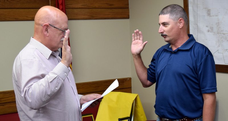Photo by Mike Eckels Marc Burden (right) takes the oath of office from Bob Tharp during the city council meeting at Decatur City Hall Oct. 9. Burden will take the open position on the Decatur Housing Authority.