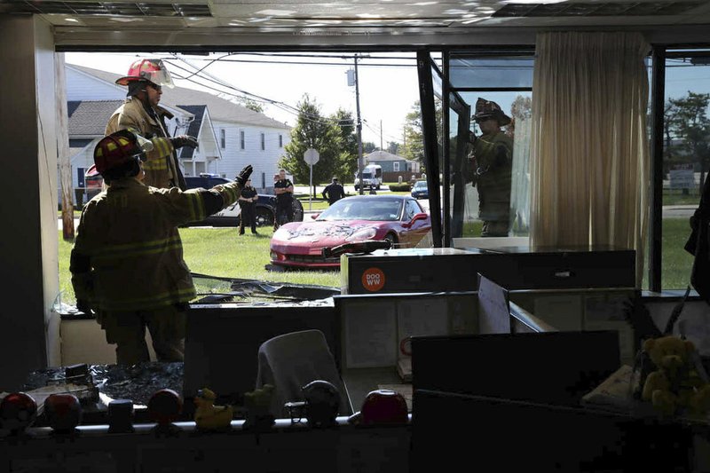 Firemen clear glass after a car drove into The Press of Atlantic City business and editorial office and crashed the window into the newsroom, in Pleasantville, N.J., Tuesday, Oct. 17, 2017. (Vernon Ogrodnek/The Press of Atlantic City via AP)
