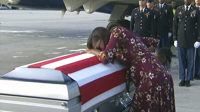 In this Tuesday, Oct. 17, 2017, frame from video, Myeshia Johnson cries over the casket of her husband, Sgt. La David Johnson, who was killed in an ambush in Niger, upon his body's arrival in Miami. 