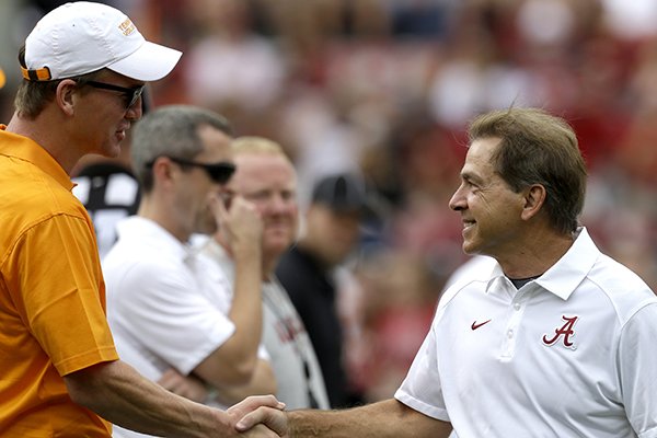 Alabama head coach Nick Saban, right, shakes hands with former Tennessee and current NFL quarterback, Peyton Manning, before the first half of an NCAA college football game, Saturday, Oct. 23, 2015, in Tuscaloosa, Ala. (AP Photo/Butch Dill)
