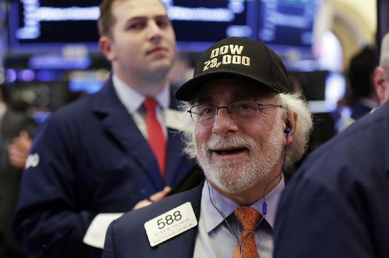 Peter Tuchman, a trader on the floor of the New York Stock Exchange, celebrates Wednesday as the Dow Jones industrial average hits a new high.  
