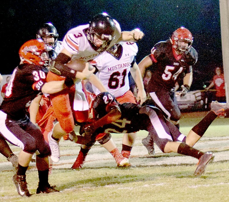 Photo by Rick Peck McDonald County quarterback Peyton Barton picks up some of his 104 yards he gained in the Mustangs' 42-32 loss to Aurora on Oct. 13 at Aurora High School.