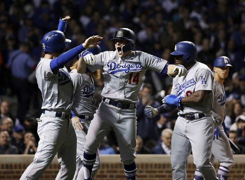 Los Angeles Dodgers left fielder Enrique Hernandez (14) celebrates after his grand slam during the third inning of Thursday night’s Game 5 of the NL Championship Series. Hernandez finished with 3 home runs and 7 RBI as the Dodgers beat the Chicago Cubs 11-1, advancing to the World Series for the fi rst time since 1988.