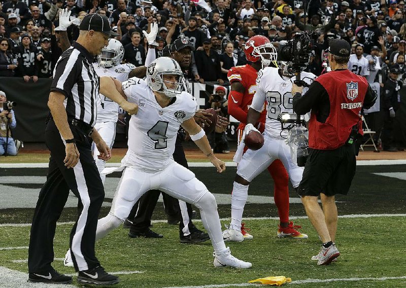 Oakland quarterback Derek Carr (4) celebrates after throwing a touchdown pass to Amari Cooper during a 31-30 victory over the Kansas City Chiefs on Thursday in Oakland, Calif. Carr went 29-of-52 passing for 417 yards and 3 touchdowns, including the game-winner to Michael Crabtree with no time remaining.