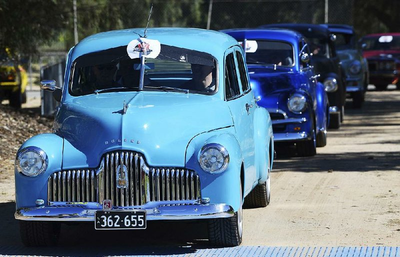 Historic Holden cars parade through the streets of Adelaide, Australia, on Sunday. Auto manufacturing in Australia will end today when the last General Motors Co. Holden sedan rolls off the  production line in Adelaide.