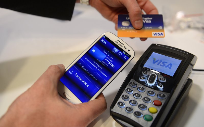 In this Wednesday, Feb. 27, 2013, file photo, a man uses the NFC payment Visa system at the Mobile World Congress, the world's largest mobile phone trade show, in Barcelona, Spain. 
