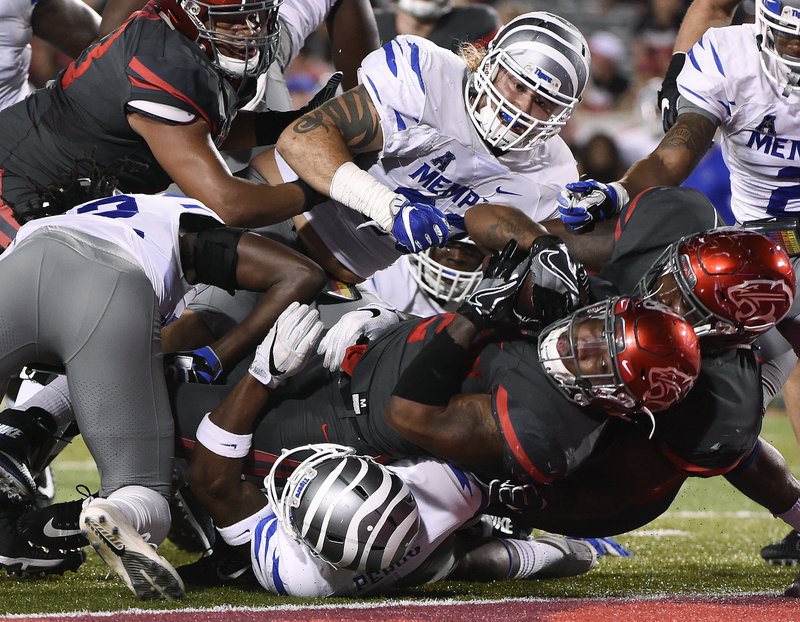Houston running back Duke Catalon, bottom, falls into the end zone for a touchdown during the first half of an NCAA college football game against Memphis, Thursday, Oct. 19, 2017, in Houston. 