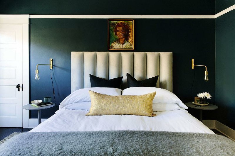 A bedroom designed by Caitlin Murray features an old abstract portrait. Murray often hunts for such portraits at flea markets or estate sales and uses them to unite the various colors in a room.