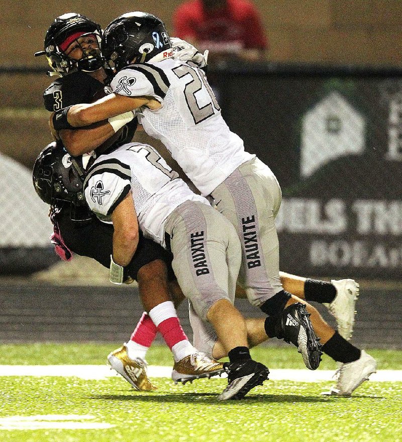 Bauxite defenders Jonah Sorvillo (2) and Seth McDowell (20) tackle Joe T. Robinson wide receiver Nathan Page (3) during the Senators’ 42-14 victory over the Miners on Friday night.