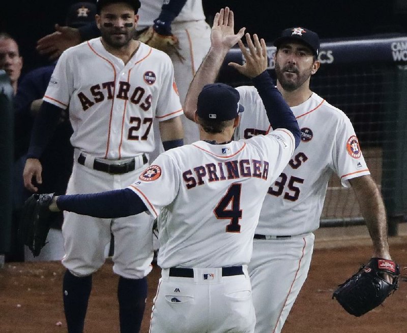 Houston Astros starting pitcher Justin Verlander congratulates George Springer (4) after Springer’s catch at the wall during the seventh inning of Friday night’s Game 6 of the American League Championship Series at Minute Maid Park in Houston. The Astros forced a seventh game with a 7-1 victory.