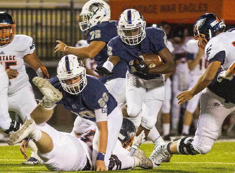 Bentonville West running back Tyreese Smallwood breaks through a hole during Friday night’s game against Rogers Heritage. Smallwood rushed for 111 yards and 2 touchdowns on 16 carries.