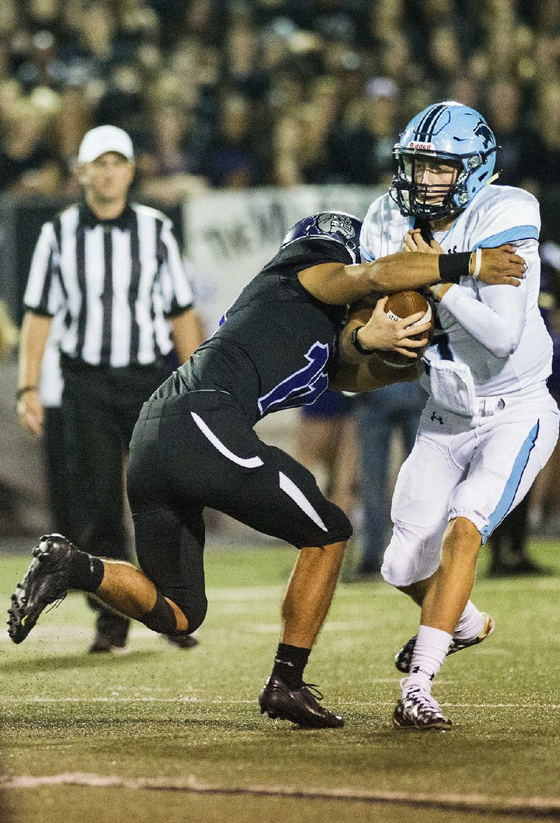 Fayetteville defensive back Kaden Martindale sacks Springdale Har-Ber quarterback Grant Allen in the fi rst half. The Bulldogs sacked Allen six times in the first half.