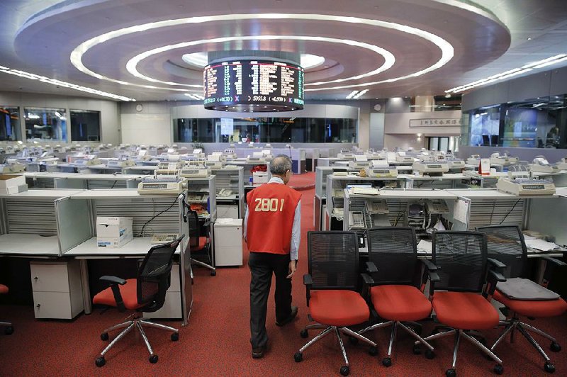 Yip Wing-keung, a trading manager at local brokerage Christfund Securities, wearing his red trading jacket, walks through the Hong Kong Stock Exchange on Thursday.