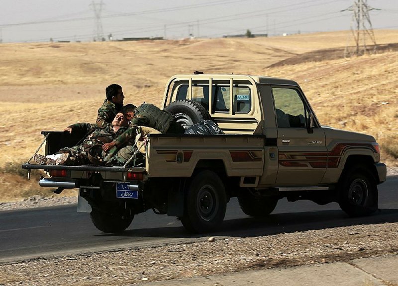 A Kurdish fighter is rushed to a hospital Friday after he was hurt in clashes with Iraqi forces in Altun Kupri outside Irbil province.