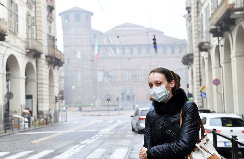 A woman takes precautions Friday on a street in downtown Turin, Italy, where air quality has worsened with an unusually long dry spell. Traffic has been ordered to a halt in parts of northern Italy.
